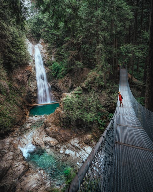 Person Standing on Silver Bridge over River