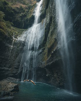 潜入雄伟瀑布底部的宁静泳池，令人惊叹