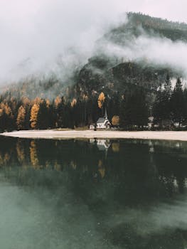 布雷斯湖的秋季景观宁静，山脉云雾缭绕，倒影一片宁静