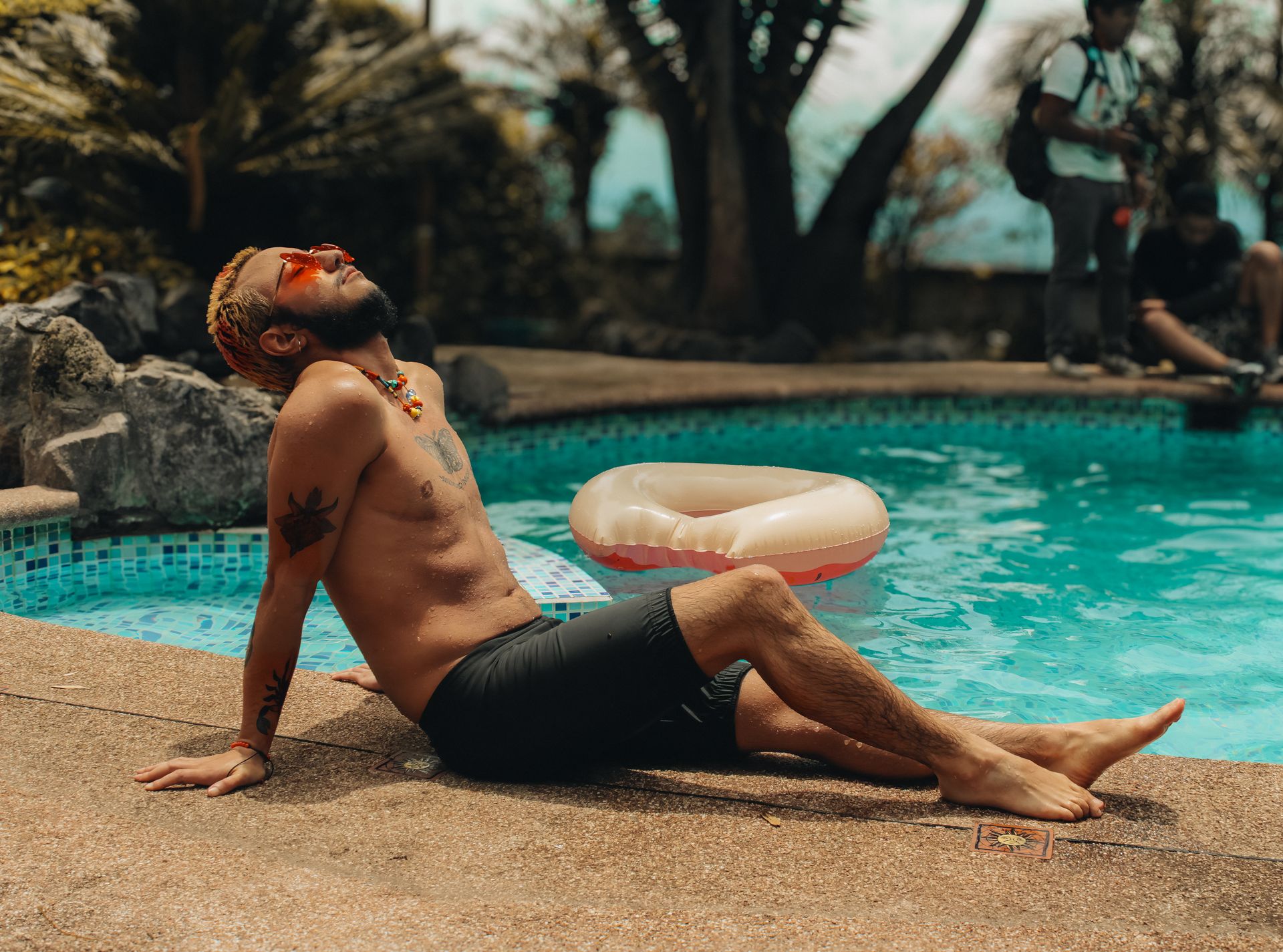 Man enjoying a sunny day by the pool in Quito, Ecuador. Perfect for summer vibes and relaxation themes.