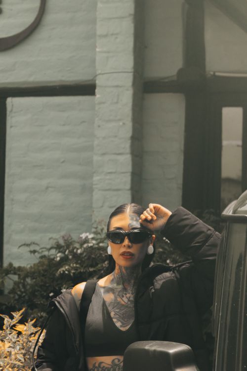 Free Tattooed woman with sunglasses and bold lips outdoors in Quito, Ecuador. Stock Photo