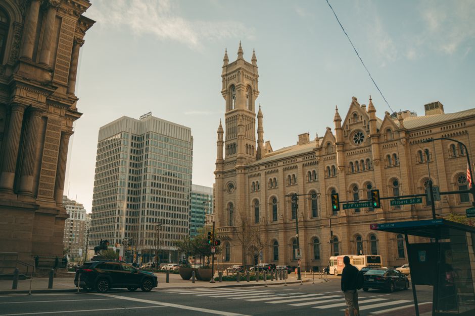 Street view of historic buildings and modern skyscrapers in Philadelphia, daylight setting.