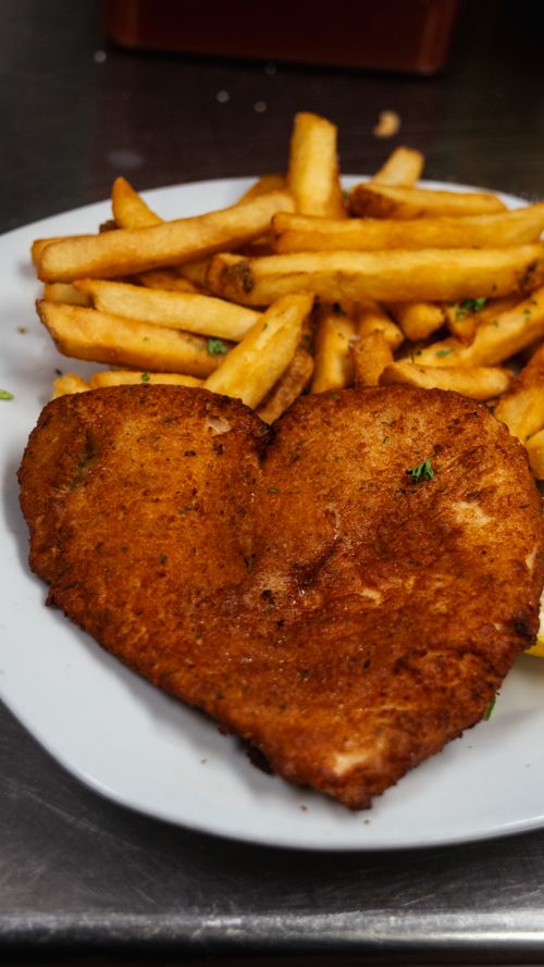 Free Heart-shaped fried chicken paired with golden crispy fries on a white plate. Stock Photo