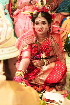 Captivating image of a bride in vibrant attire during an Indian wedding ceremony.