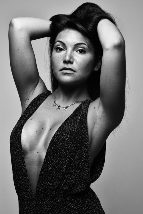 Free Striking black and white portrait of a woman posing confidently with hands in hair. Stock Photo