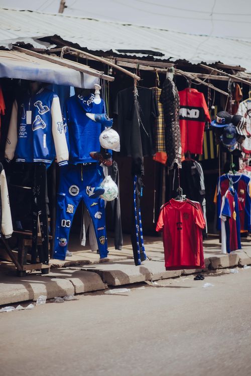 Free Colorful clothing displayed at a lively street market in Nigeria, showcasing local fashion. Stock Photo