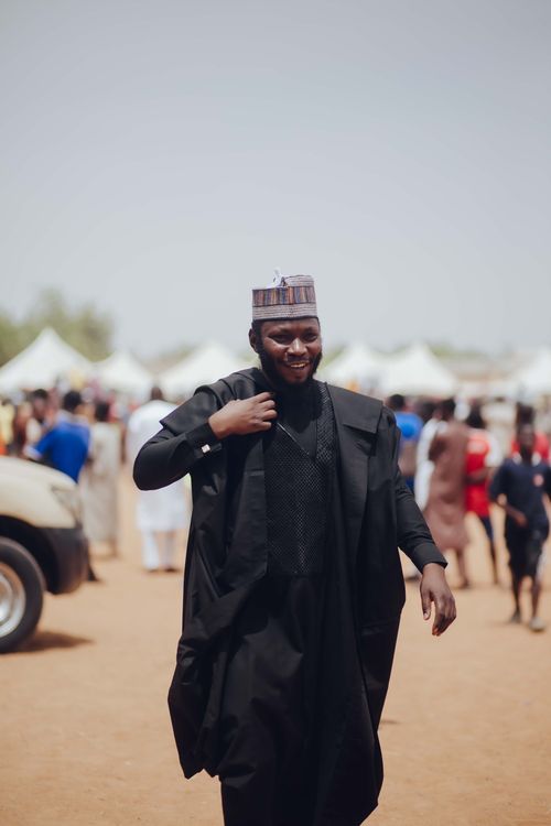 Free A man in traditional Nigerian attire smiles outdoors at a cultural event. Stock Photo