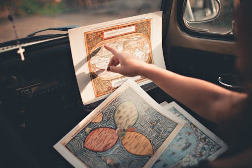 Free Person Inside A Vehicle Pointing On A Map  Stock Photo