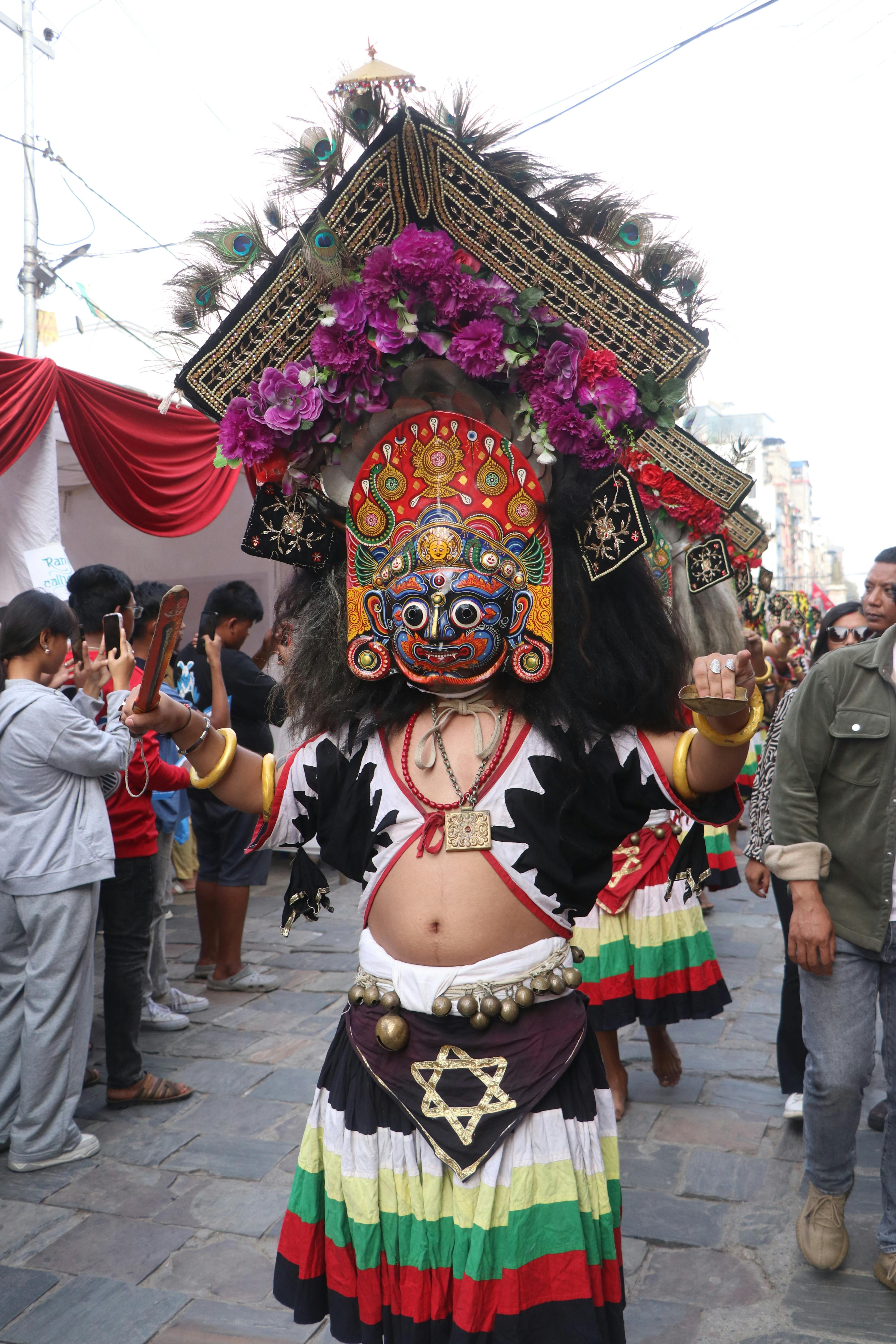 Colorful Newar dancer in vibrant traditional attire during a festival in Kathmandu, Nepal.
