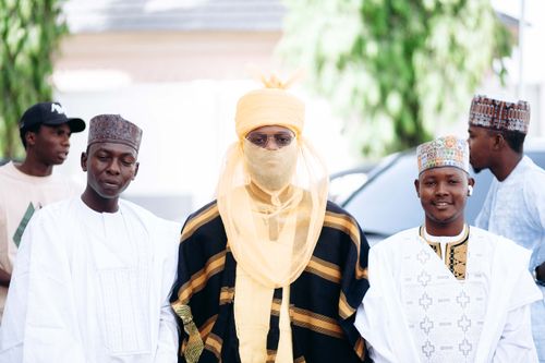 Free Men dressed in vibrant traditional African attire stand confidently outdoors. Stock Photo