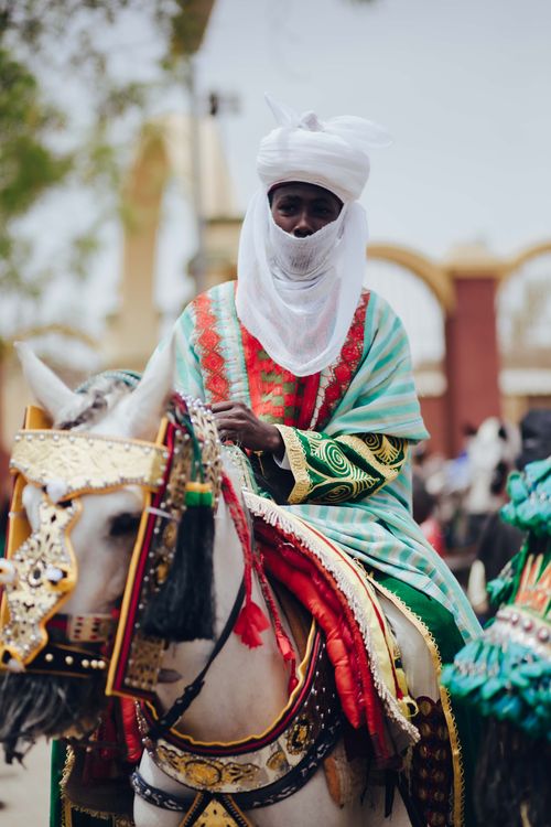 Free A Nigerian horseman dressed in vibrant traditional attire, showcasing cultural heritage. Stock Photo