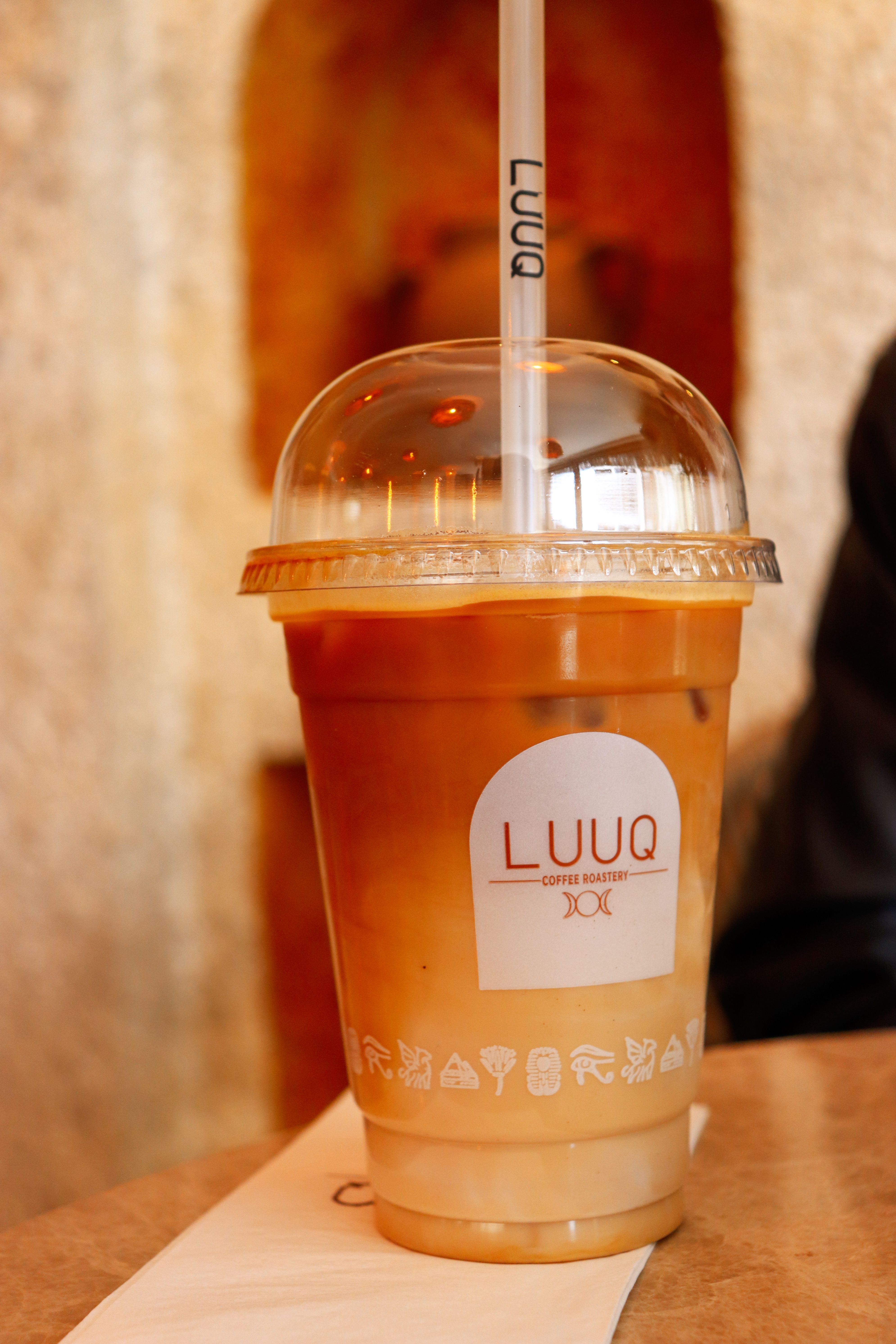 A refreshing iced coffee in a branded plastic cup at a chic cafe setting.