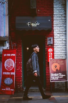 A fashionable individual walks past the Populair Hostel entrance in Bandung, Jawa Barat, Indonesia.