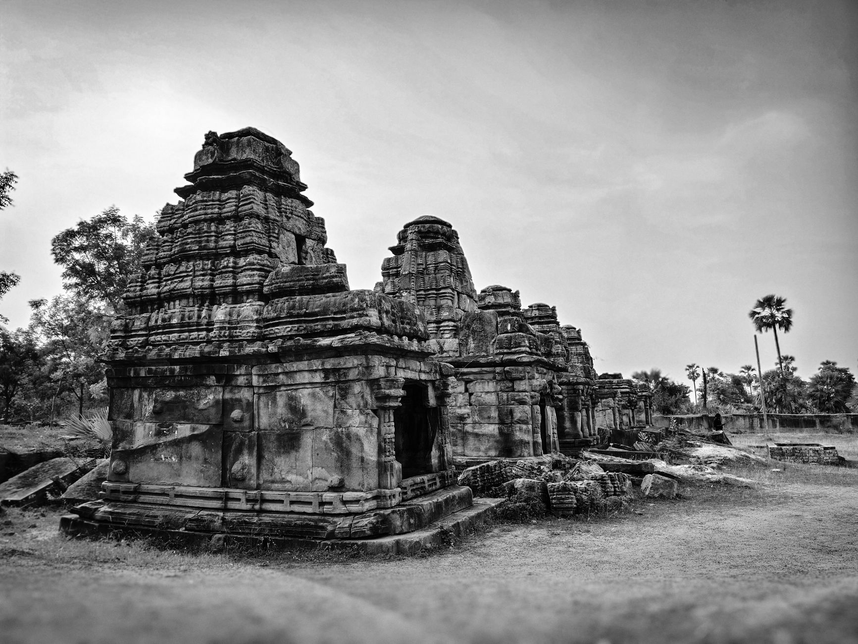 Black and white image of ancient stone ruins in a deserted outdoor setting.