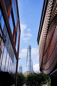 A view of Shanghai Tower between two modern architecture buildings in daylight.