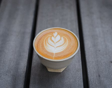 A beautifully crafted latte with art in a ceramic cup on a wood table, Tokyo, Japan.