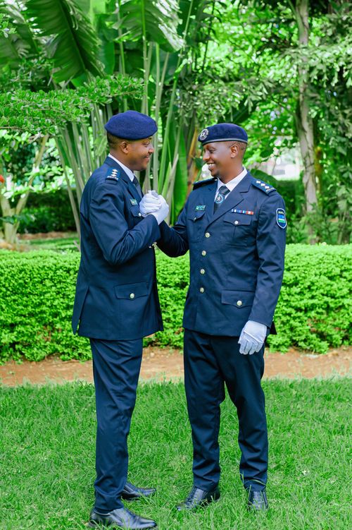 Free Two police officers exchange a handshake in a green park, showing camaraderie and teamwork. Stock Photo