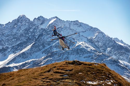 Free A helicopter flies over the snowy peaks of the Korutany mountains on a clear day. Stock Photo