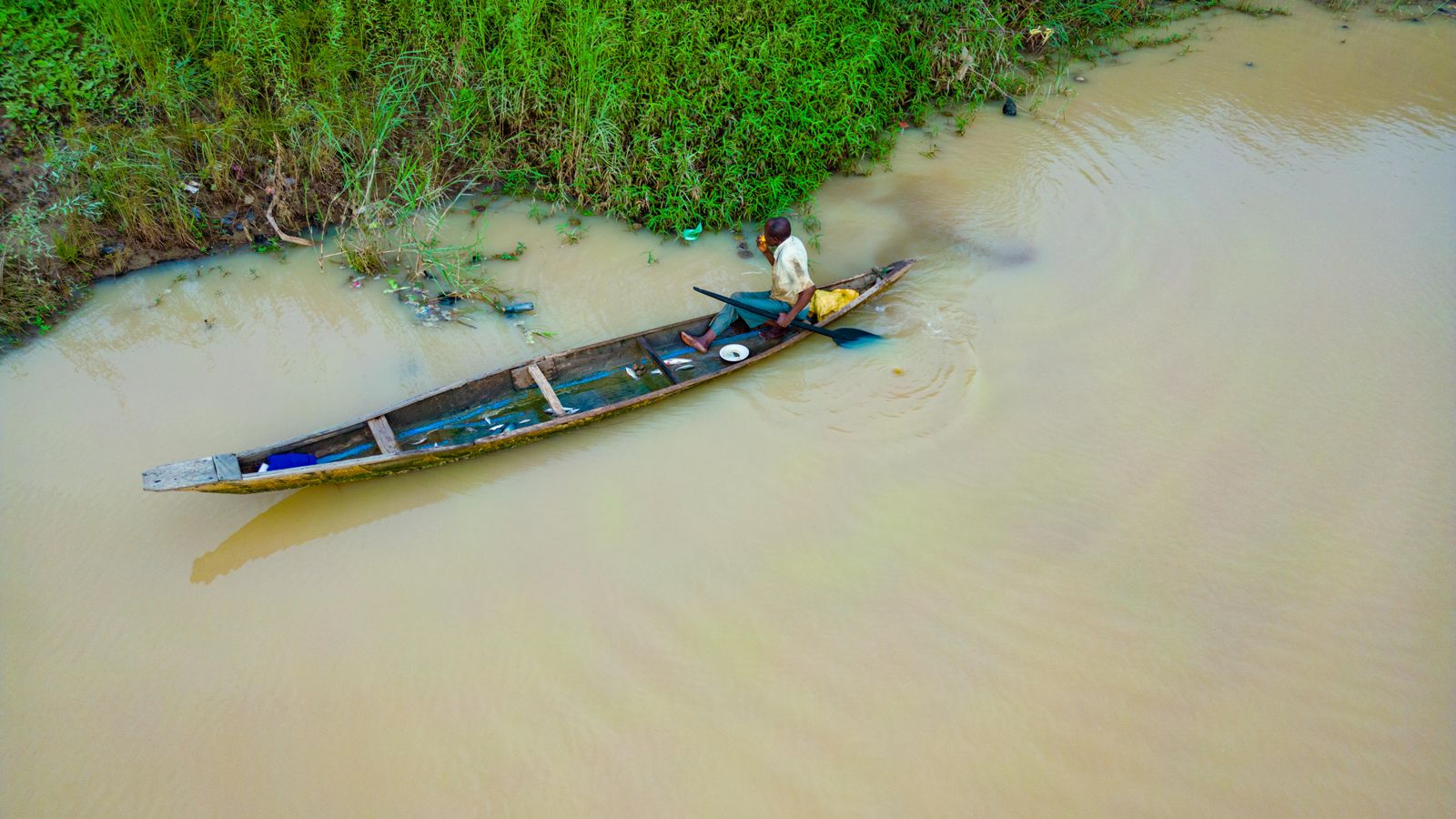 Fisherman canoeing on kaduna river nigeria, Congo