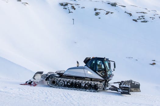 Snow plow grooming ski slopes in the alpine region of Heiligenblut, Austria.