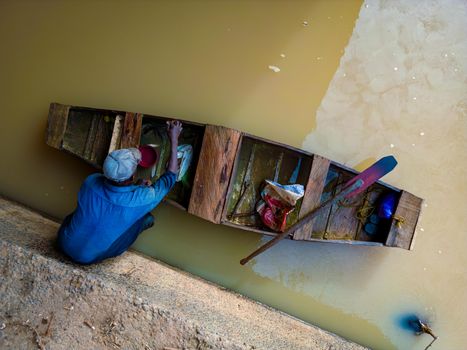 Fisherman in canoe on Kaduna River, Nigeria, showcasing local lifestyle.