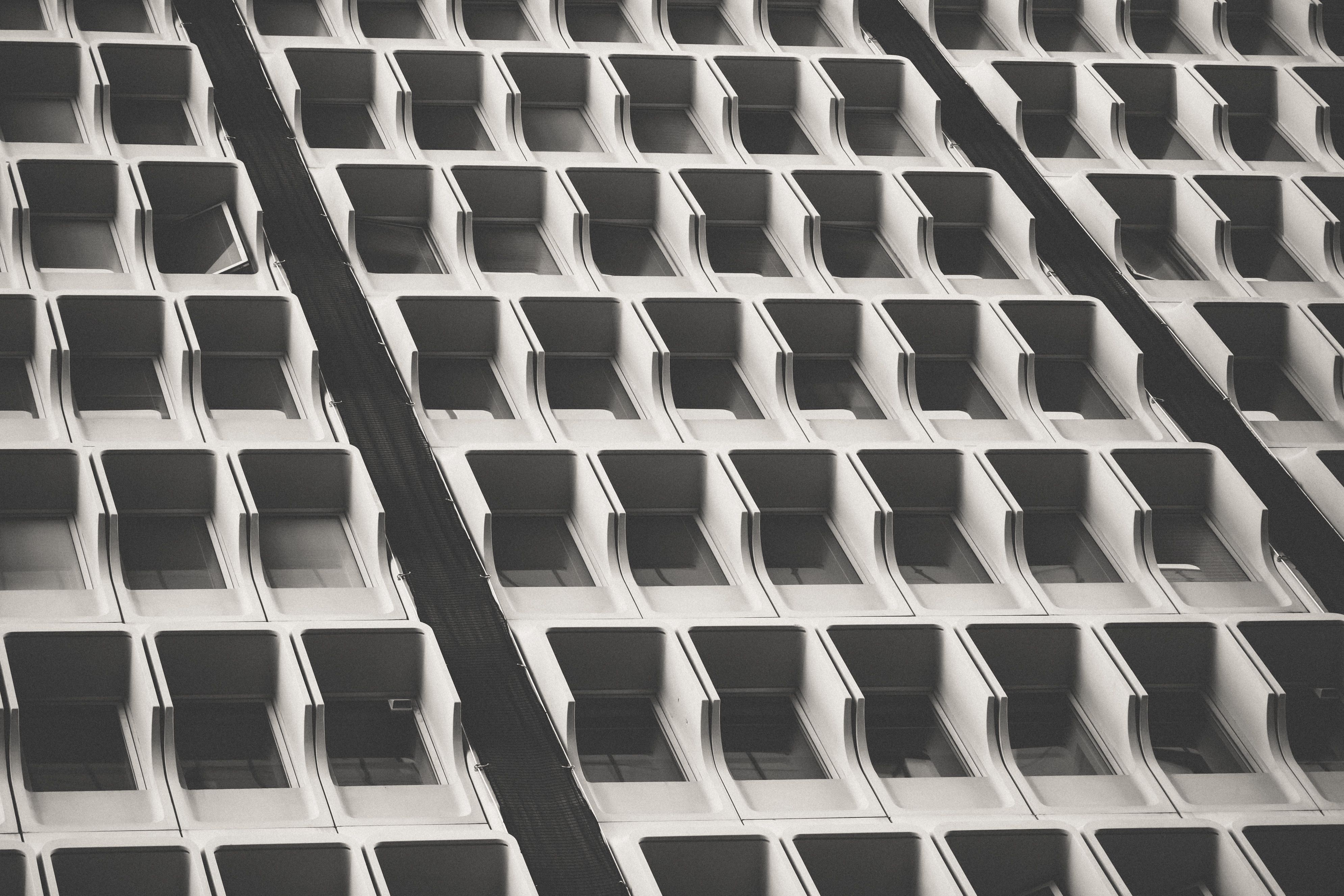 Monochrome abstract pattern of a building facade, focusing on symmetry and repetition.