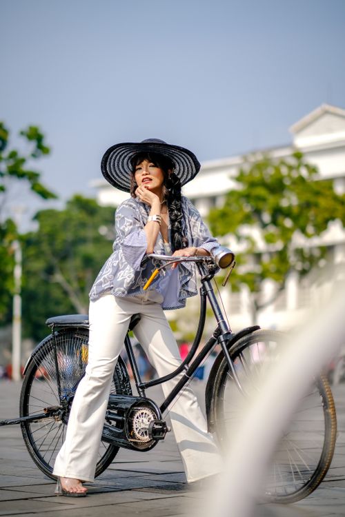 Free Woman in elegant outfit posing with a bicycle in Fatahillah Square, Jakarta. Stock Photo