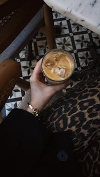 Stylish iced latte on a vintage tile floor at an outdoor cafe in Bursa, Türkiye.