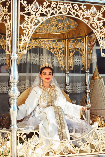 Stunning bridal portrait in ornate gold and silver throne, showcasing cultural elegance.
