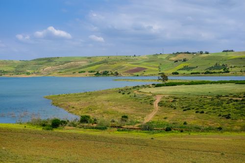 Free Idyllic landscape with a lake surrounded by rolling hills in Rabat, Morocco. Perfect for nature enthusiasts. Stock Photo