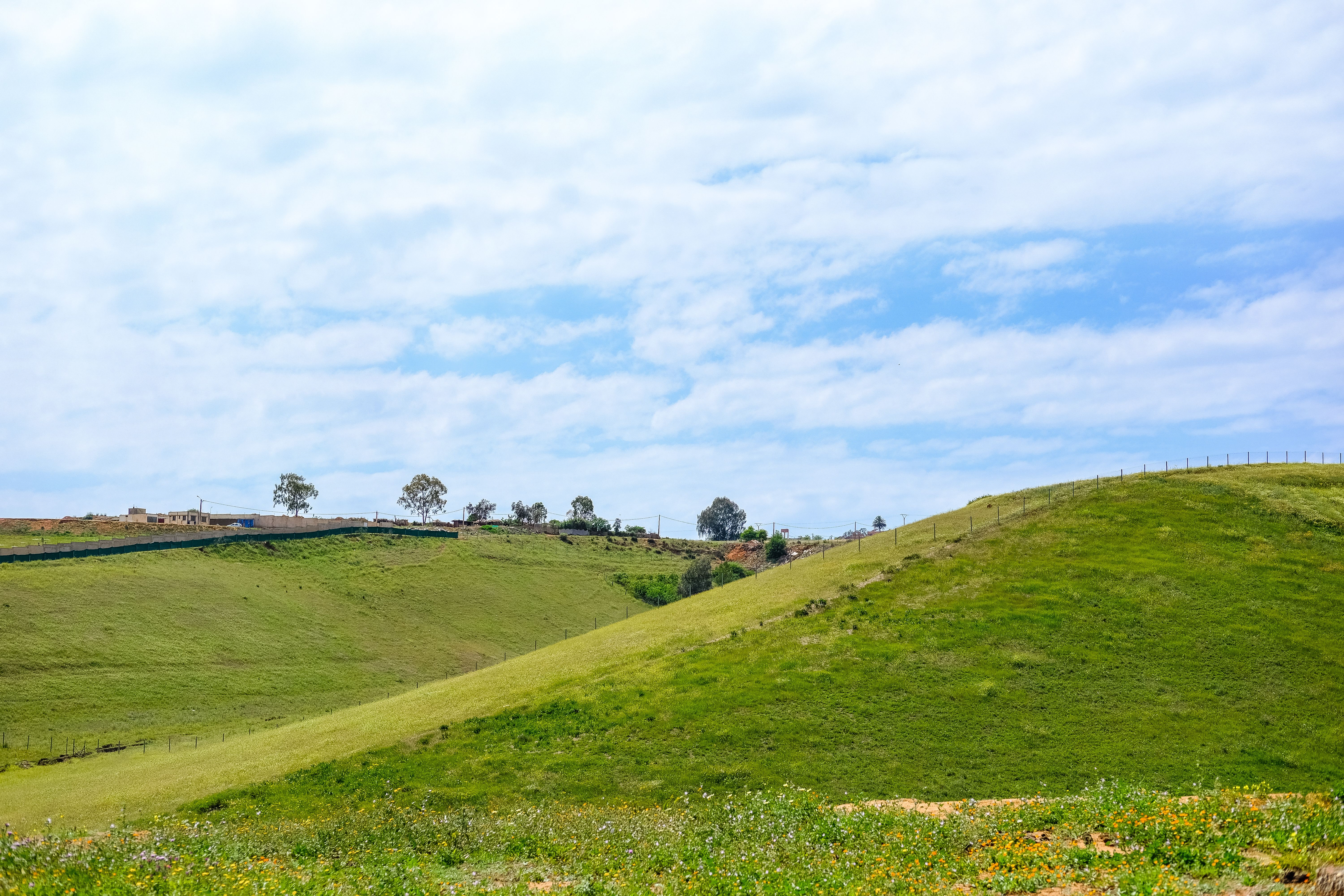 Rolling Green Hills Under Cloudy Sky in Rabat · Free Stock Photo