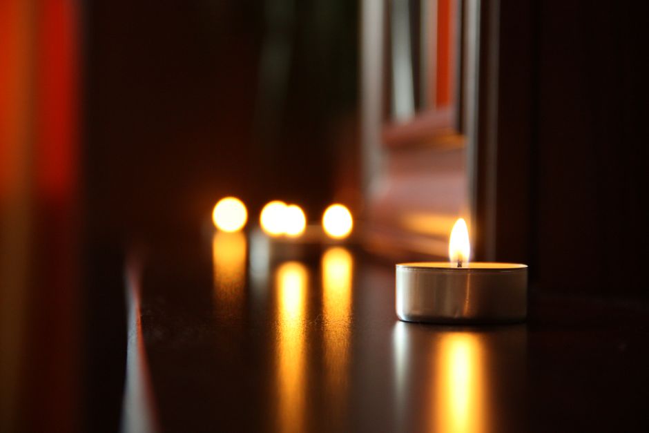 Soft focus candlelight on a reflective surface, exuding a warm and romantic atmosphere.