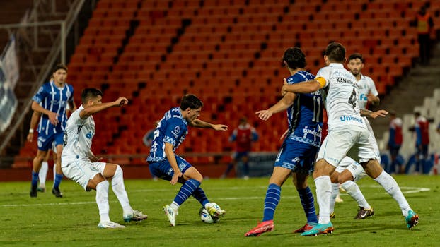 Soccer players competing in a tense match with dynamic movements outdoors at night.