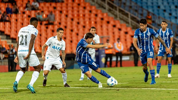 Dramatic moment during a soccer match with players in action on a stadium field.