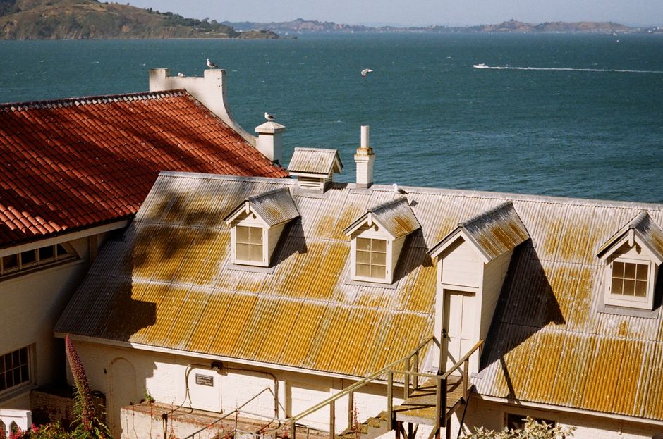 Rustic rooftops with a scenic view of San Francisco Bay, capturing serene water and island landscapes.