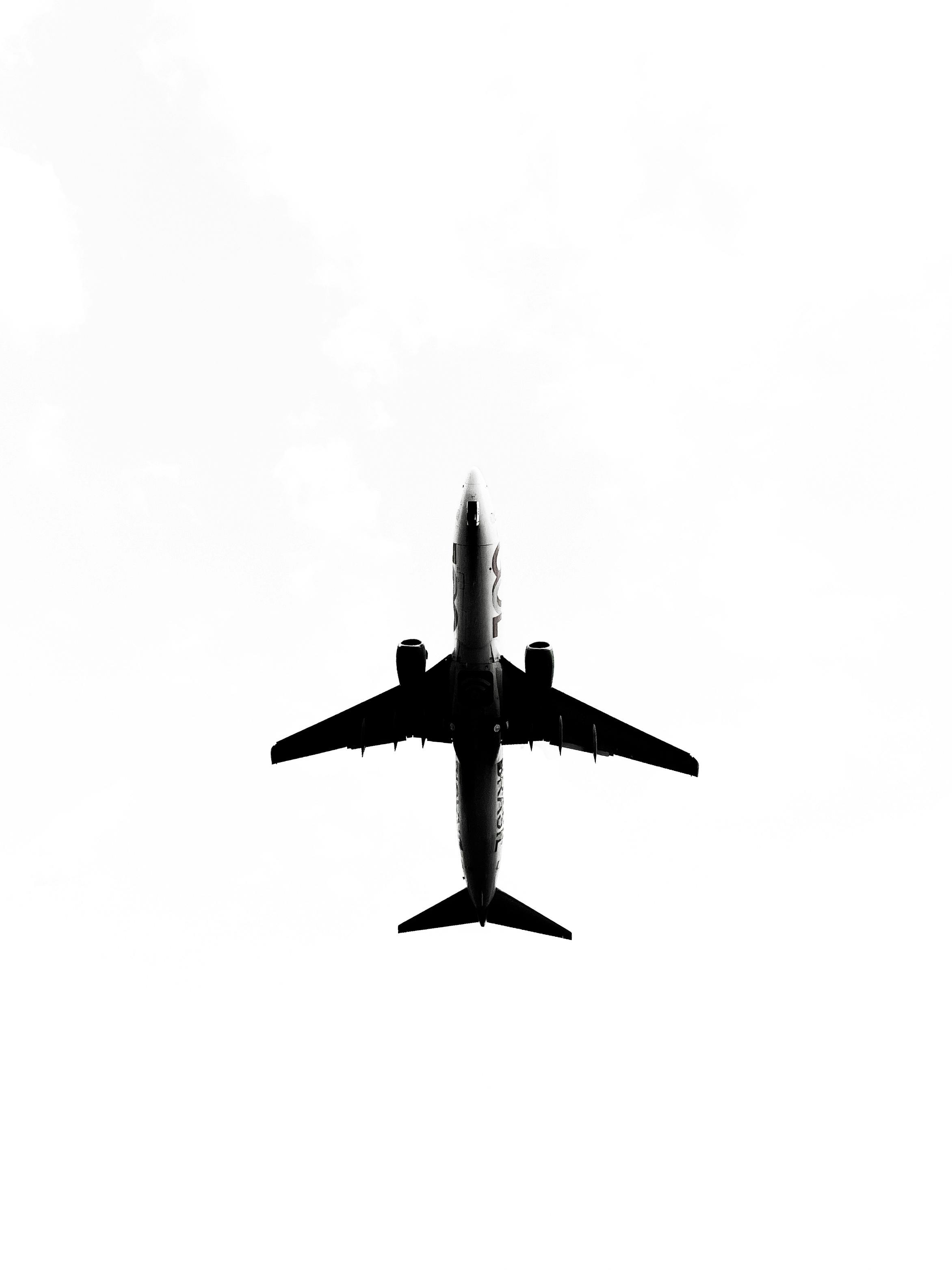 De franc Silueta d'un avió comercial capturada des de baix contra un cel clar. Foto d'estoc