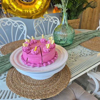 Pink frosted birthday cake with lit candles — photo by Nadiye Şamlı on Pexels