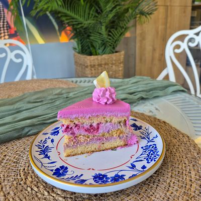 Slice of pink layered cake on a patterned plate. Photo by Nadiye Şamlı on Pexels.