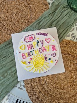 A vibrant birthday cake with colorful decorations and whimsical text.
