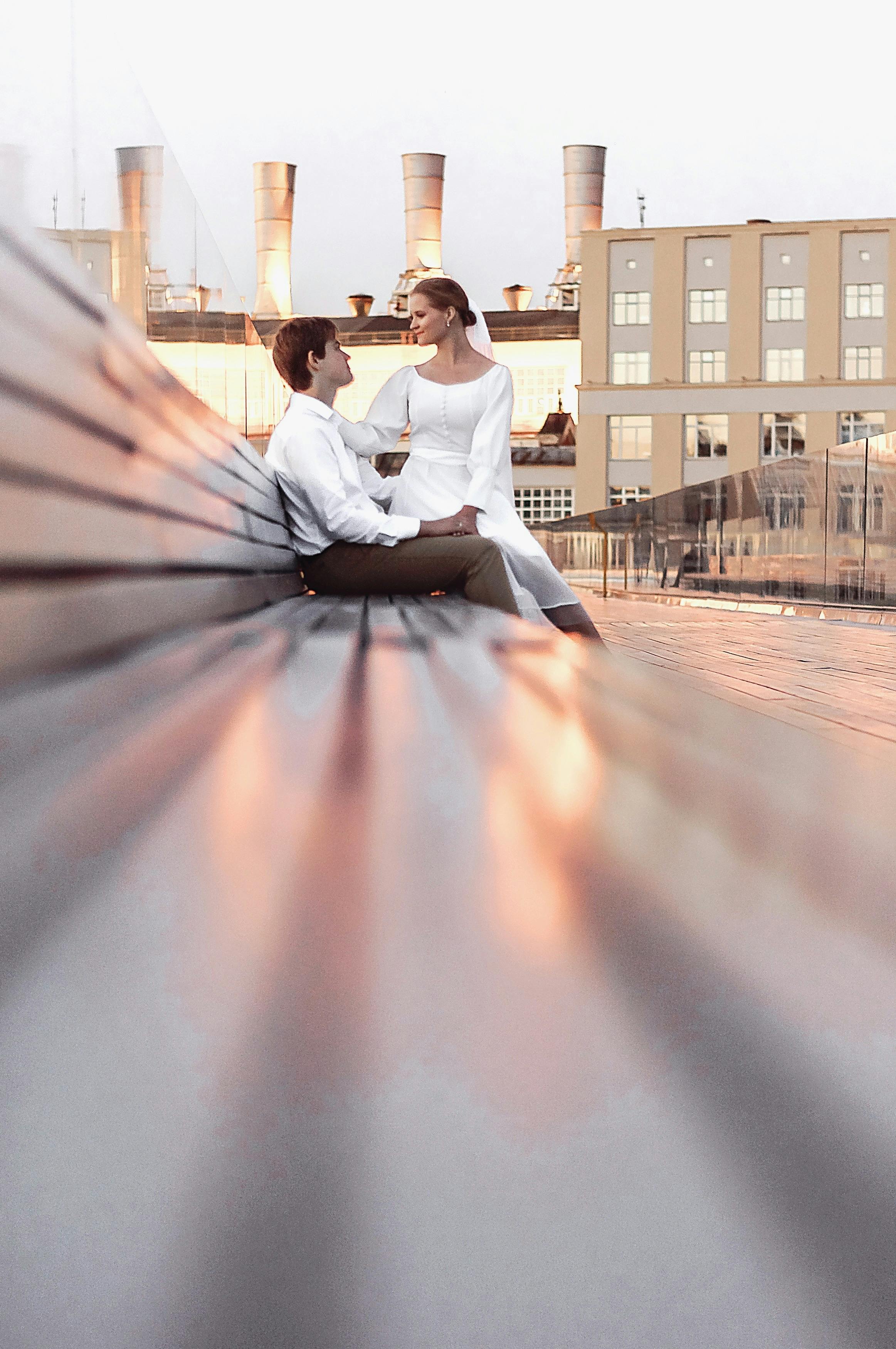 Romantic moment captured between a couple sitting on a bench during daylight.