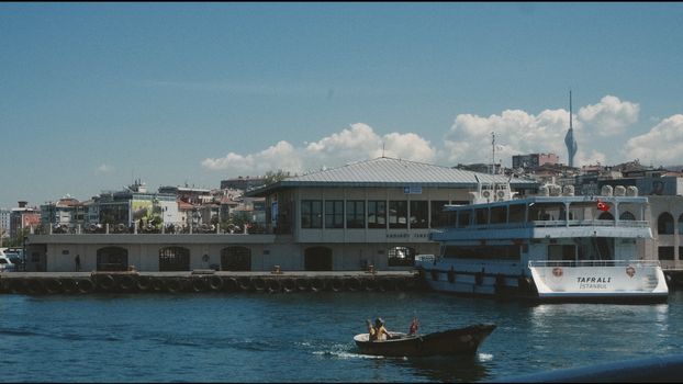 Scenic view of Kadikoy ferry dock in Istanbul with calm waters and blue sky.