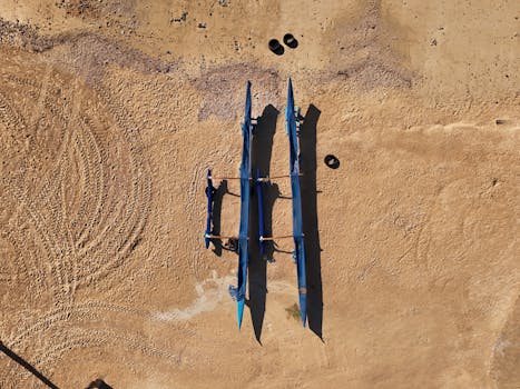 Aerial shot of three blue canoes on a sandy beach in Honolulu, Hawaii, during the day.