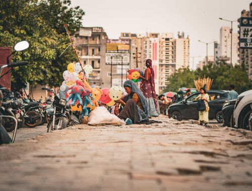 Free Vendors selling colorful balloons on a busy street in Noida, India, capturing the essence of daily life. Stock Photo
