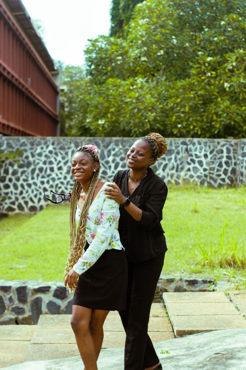 Free Two women laughing and enjoying a sunny day outdoors. Vibrant and happy atmosphere. Stock Photo