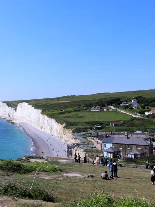 Free Scenic view of Birling Gap's chalk cliffs and beach with people enjoying the summer day. Stock Photo