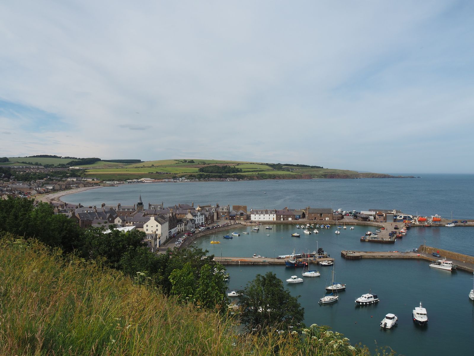 Stonehaven harbour in Aberdeenshire with moored boats and the coastal town behind