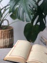 Open Quran on Table with Monstera Plant