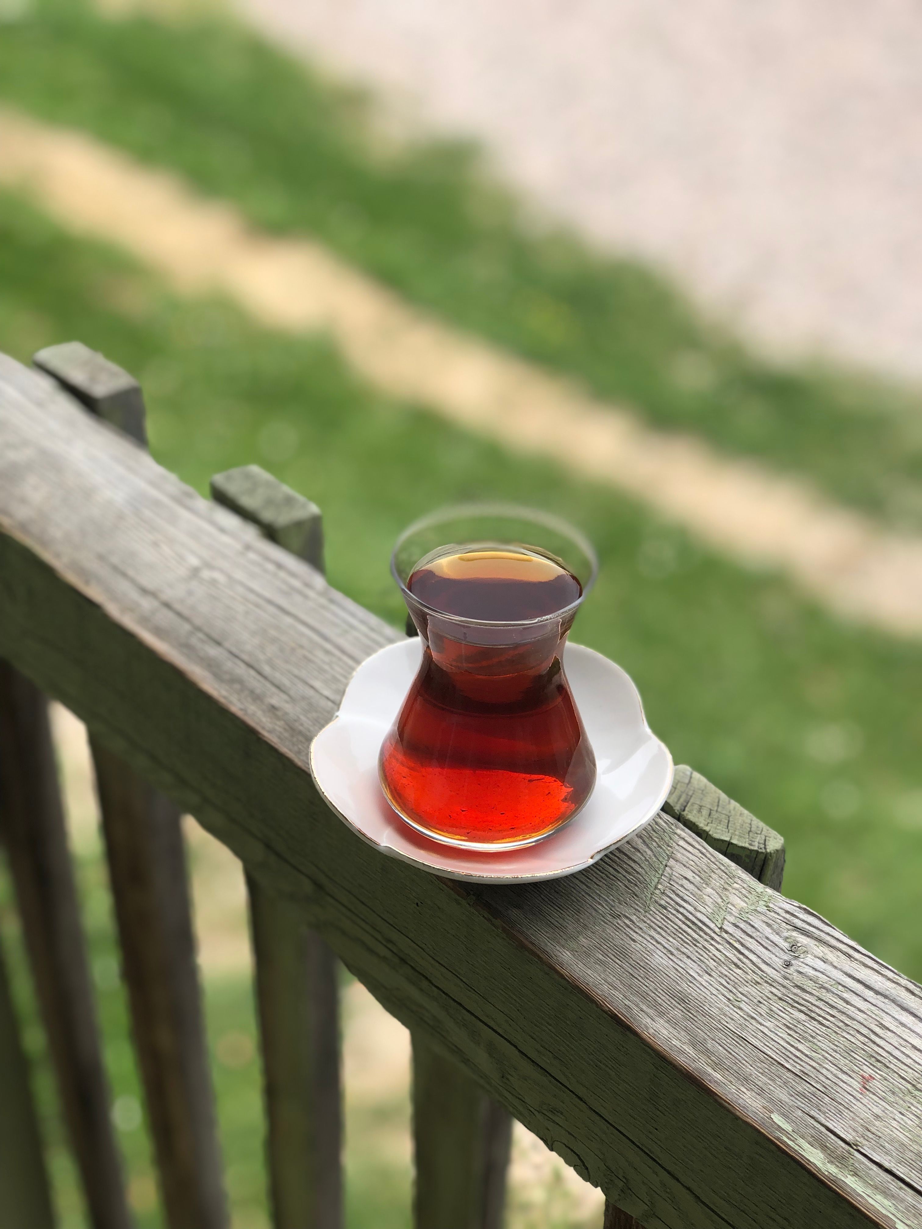 Glass of Turkish Tea on a Rustic Wooden Rail Outdoors · Free Stock Photo