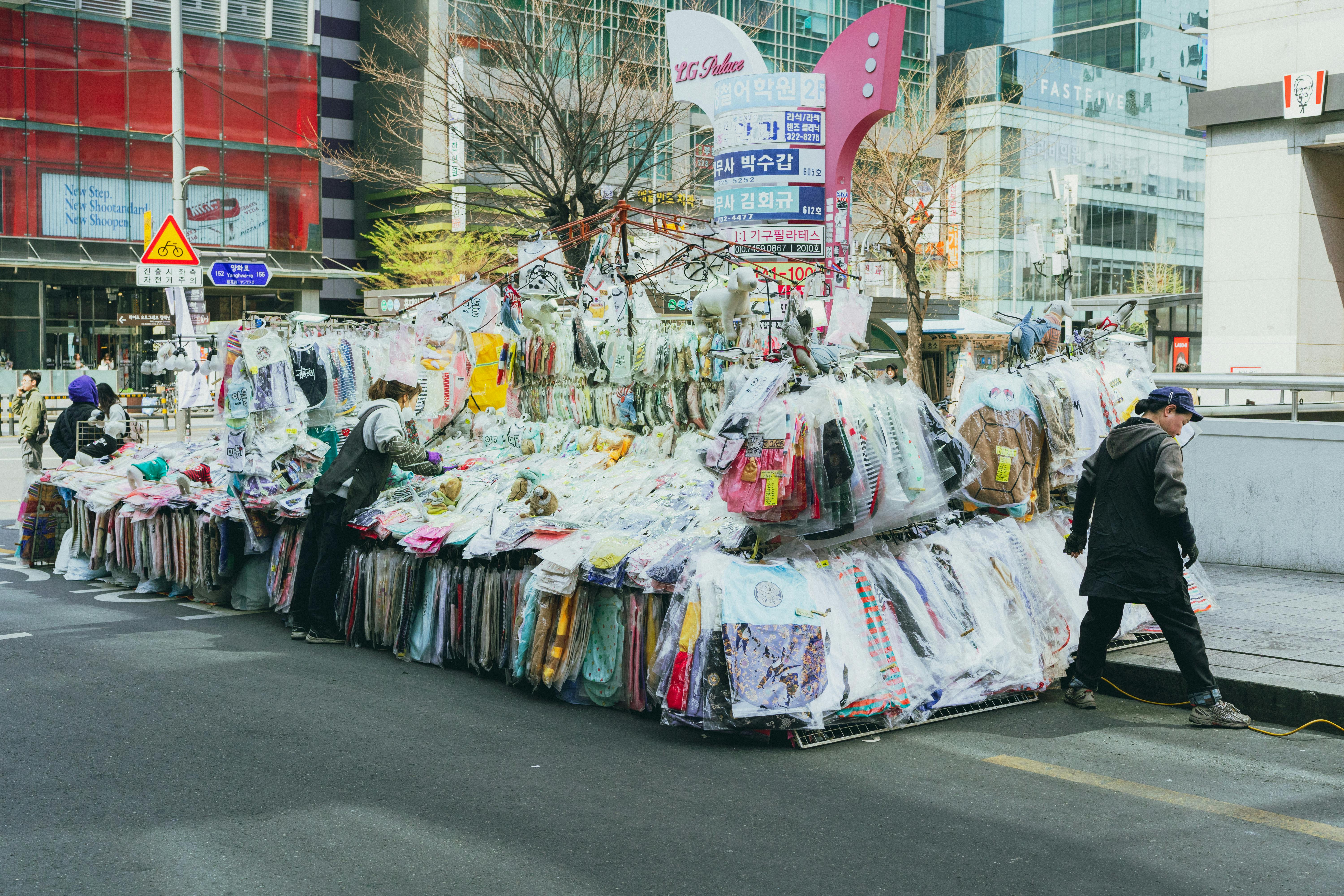 Vibrant street market in Seoul showcasing colorful clothing and lively urban life.