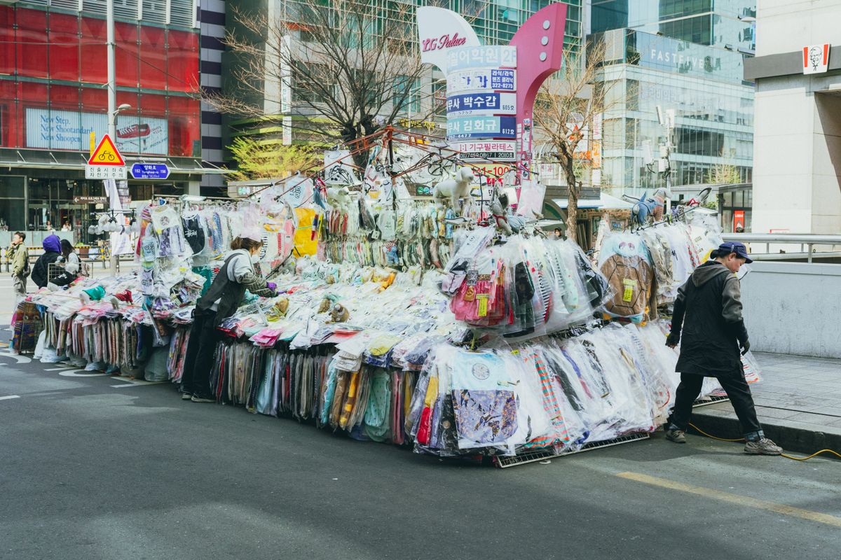 A lively Seoul shopping street with clothing and city movement